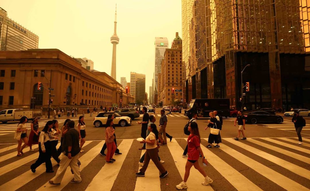 Personas caminan por el centro de Toronto mientras el humo de los incendios forestales en el norte de Ontario provoca una mala calidad del aire en la ciudad; Toronto, Ontario, Canadá, 15 de julio de 2026. Foto: AFP