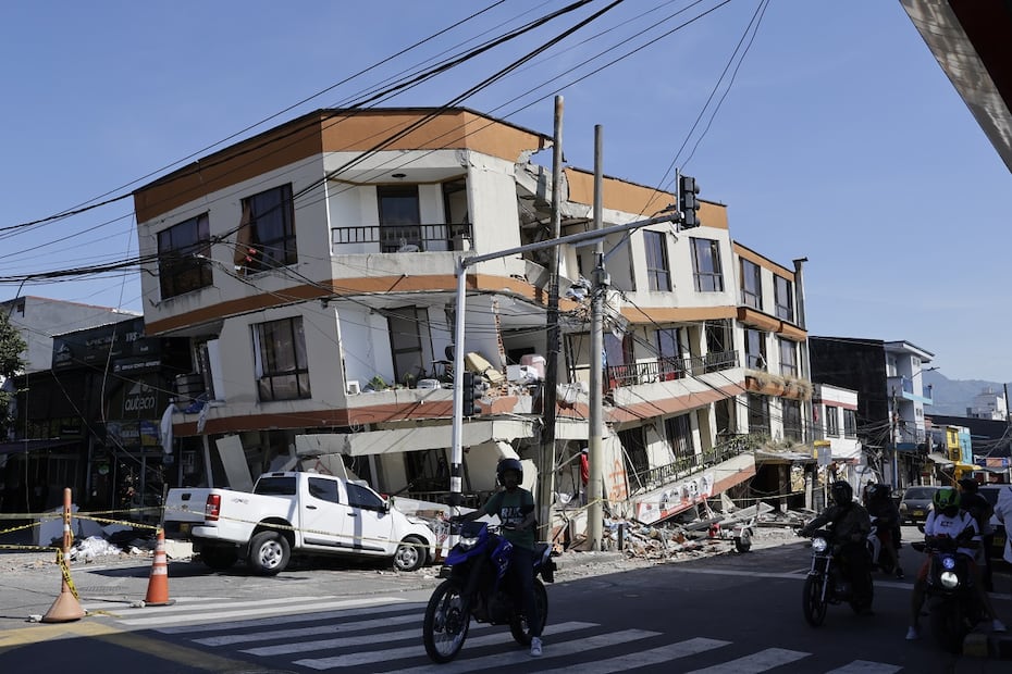Personas transitan en motocicletas frente a una edificación destruida tras el terremoto de magnitud 7.4 que sacudió la víspera la mayor parte de Colombia, en Pereira. Foto: EFE