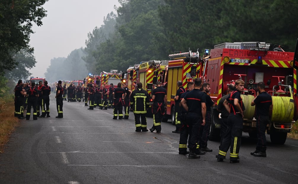 Elementos del cuerpo de bomberos permanecen en una carretera cercana a Lacanau durante las labores de atención por los incendios en el suroeste francés (25/07/2026). Foto: AP