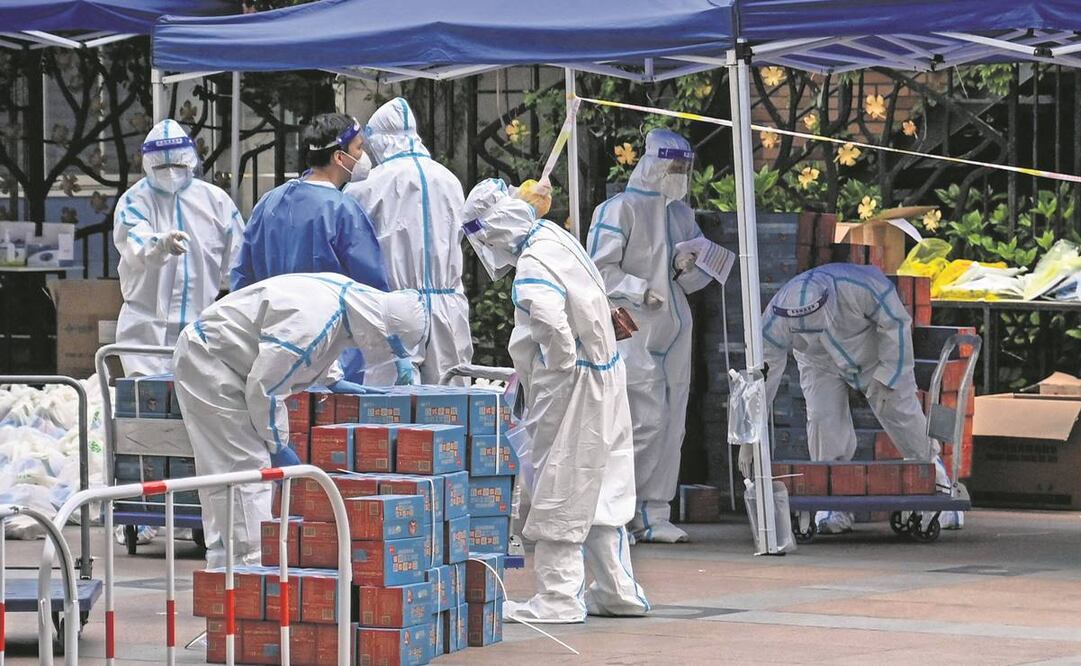 Empleados revisan comida entregada por el gobierno en Shanghái. Foto: Héctor Retamal/AFP