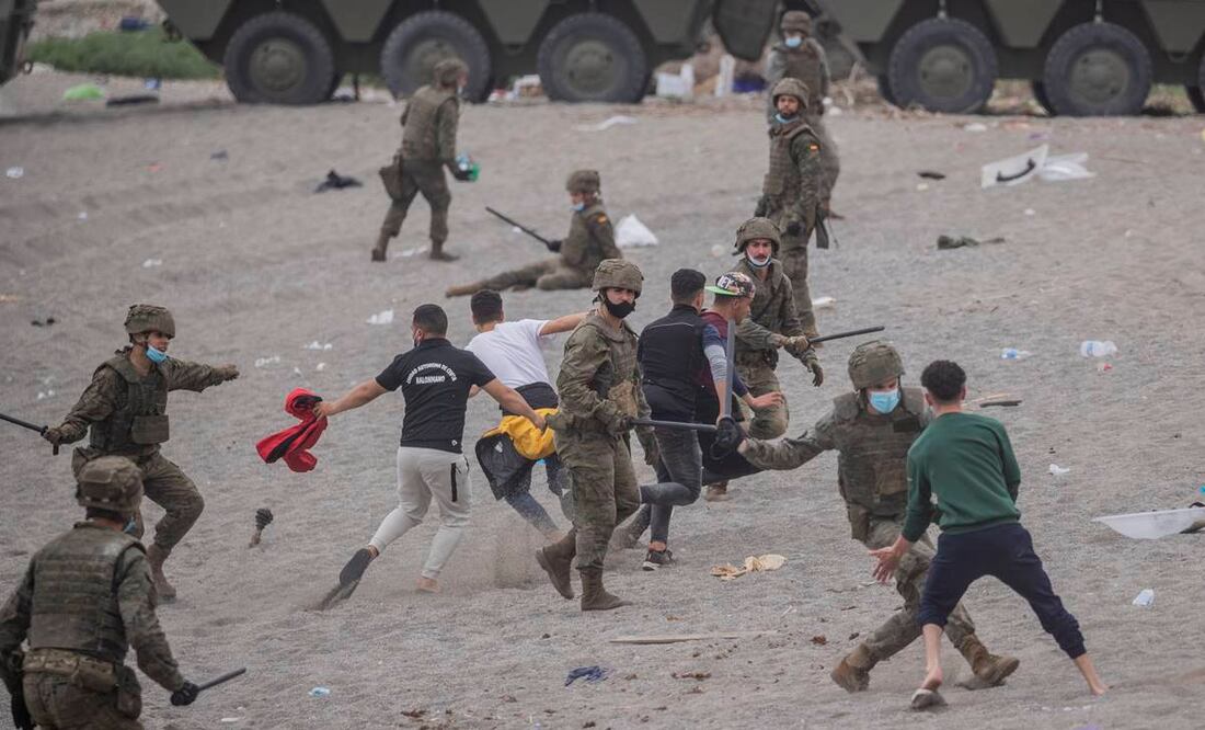 Soldados españoles vigilan la playa mientras los migrantes esperan en el enclave español de Ceuta, cerca de la frontera entre Marruecos y España. Foto: Bernat Armangue/AP.