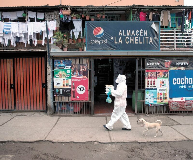Una vecina de la comuna de Renca, en Santiago de Chile, se prepara para entregar almuerzos a domicilio a familias contagiadas. ALBERTO VALDÉS. EFE