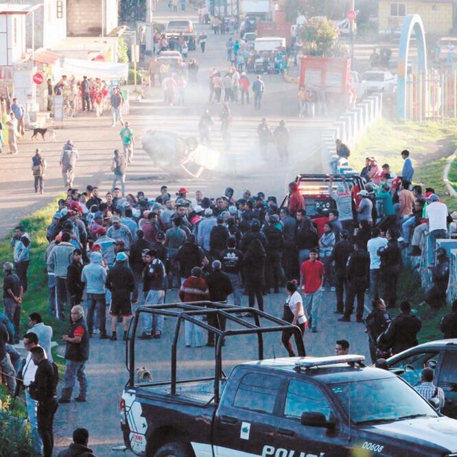 Una muchedumbre quemó un vehículo y amenazó con linchar a los agentes estatales para tratar de evitar la aprehensión de un colono acusado del robo de un taxi. Foto: XAVIER OMAÑA. EL UNIVERSAL