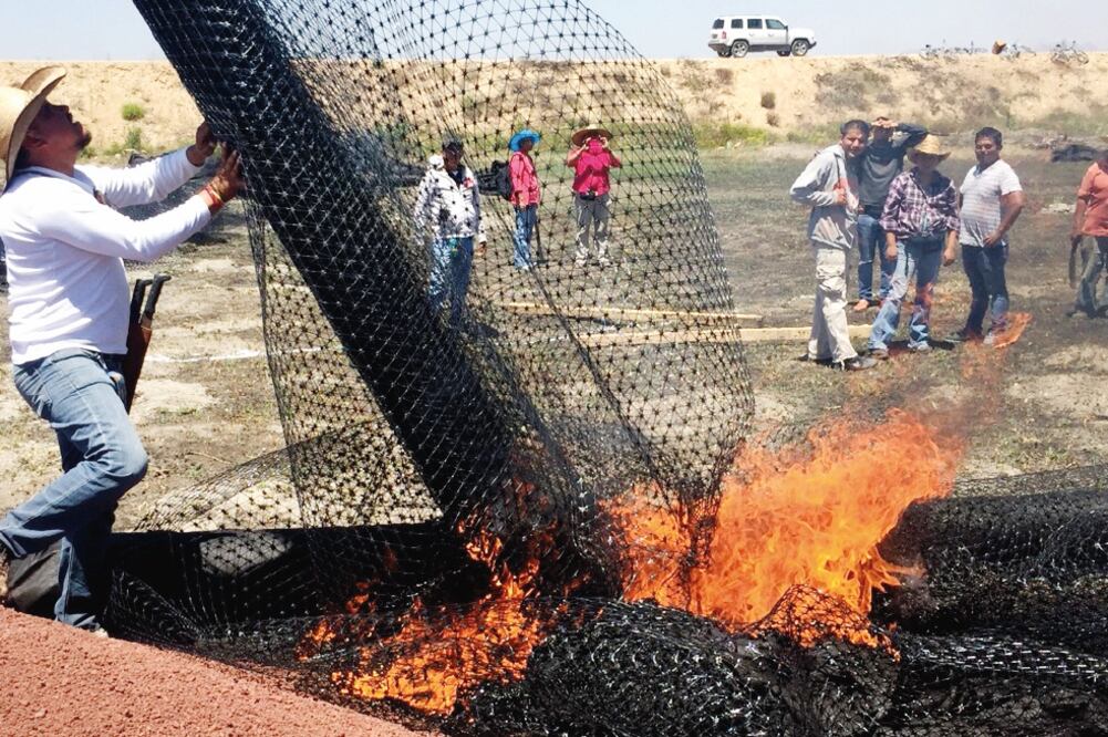 Ejidatarios con machete en mano quitaron la membrana geotextil y malla de plástico que se utilizaría para la autopista y al quemaron (ESPECIAL)