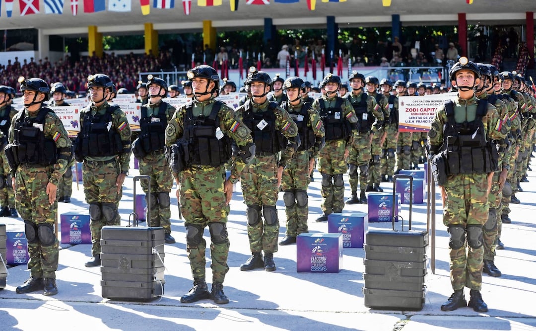 Soldados venezolanos, junto a máquinas de votación y urnas mientras participan en un desfile militar mostrando material que se utilizará en las elecciones presidenciales, en Caracas. Foto: AFP