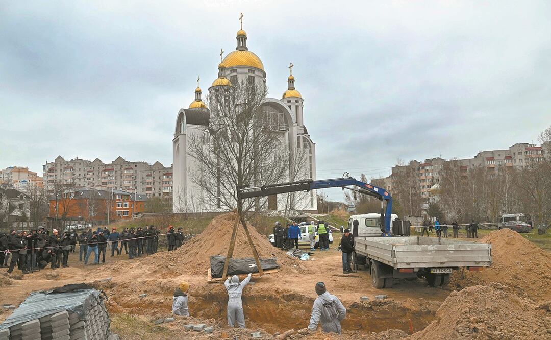 En los terrenos de la iglesia de Todos los Santos de St. Andrew las autoridades ucrananias exhumaron cuerpos de una fosa común hallada en Bucha. Foto: SERGUÉI SUPINSKY/ AFP