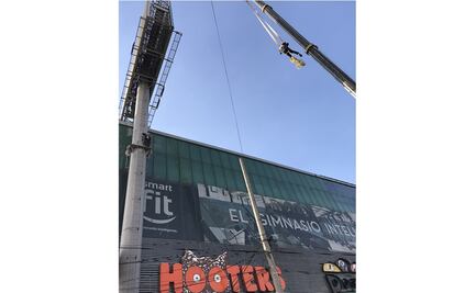 Empleado sube a espectacular para impedir retiro de anuncio propiedad de edil