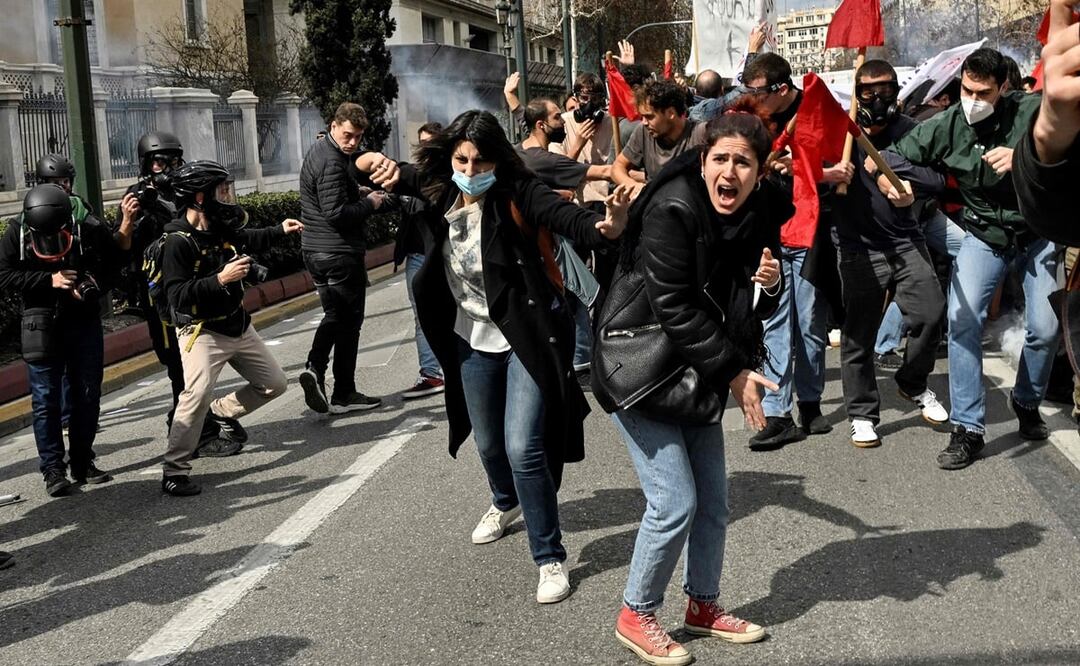 Jóvenes se enfrentan a la policía antimotines, en Atenas. Foto: AFP