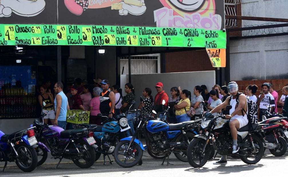 Tras ataque de EU en Venezuela, cientos de comercios permanecen cerrados por lo que venezolanos hacen filas para comprar comida en donde se pueda. FOTO: Jacinto Oliveros / AFP