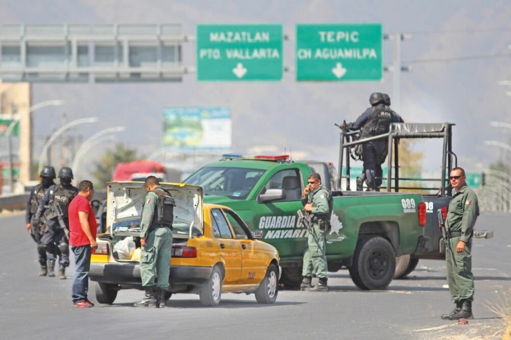 Desde la madrugada de ayer, después de que los cuerpos de El H-2 y los siete sujetos que trataron de defenderlo fueron llevados a la morgue, la policía de Nayarit resguarda los accesos viales a la zona donde ocurrió el enfrentamiento (ULISES RUIZ BASURTO)