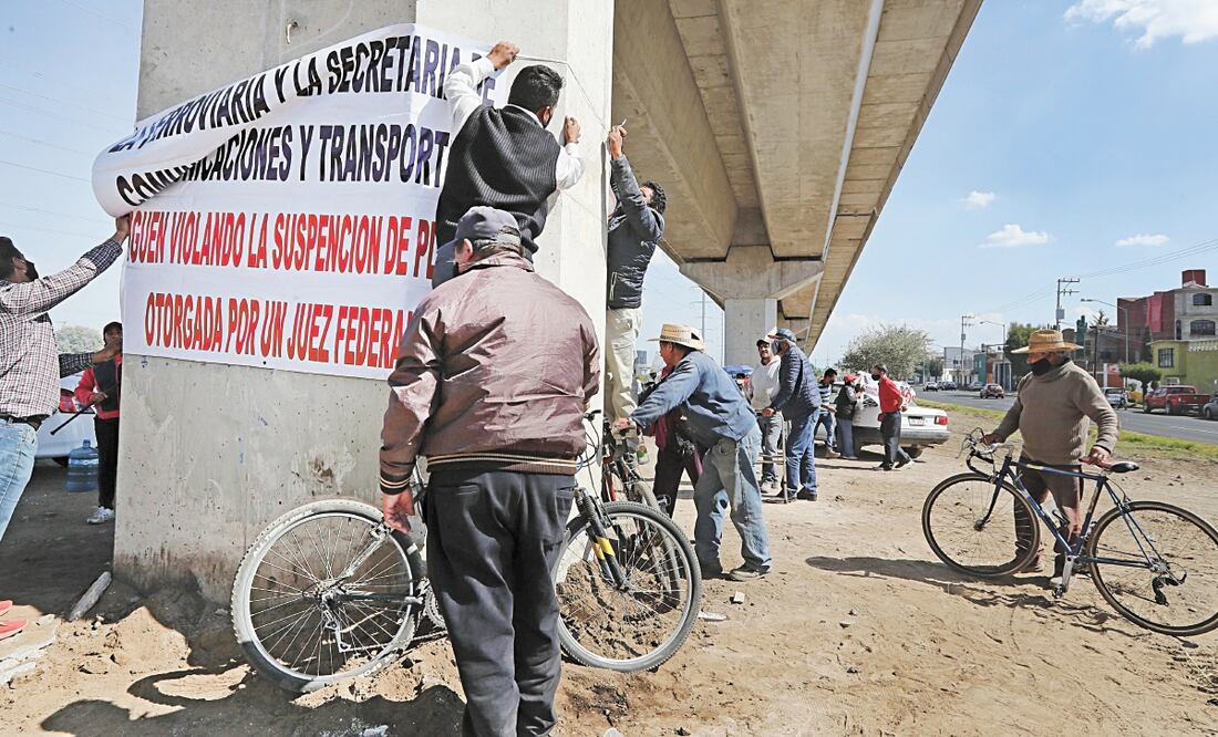 Los ejidatarios custodian las columnas del tren. Foto: JORGE ALVARADO. EL UNIVERSAL