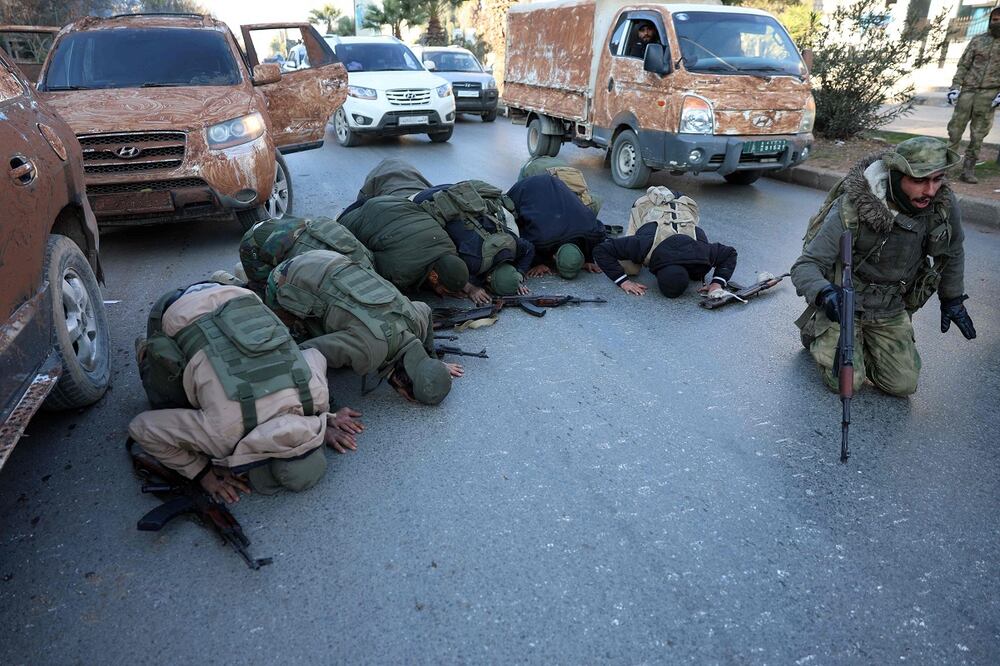 Los combatientes antigubernamentales se arrodillan para orar en una calle de Aleppo, después de que los yihadistas y sus aliados entraron en la ciudad del norte de Siria, el 30 de noviembre de 2024. Foto: AFP