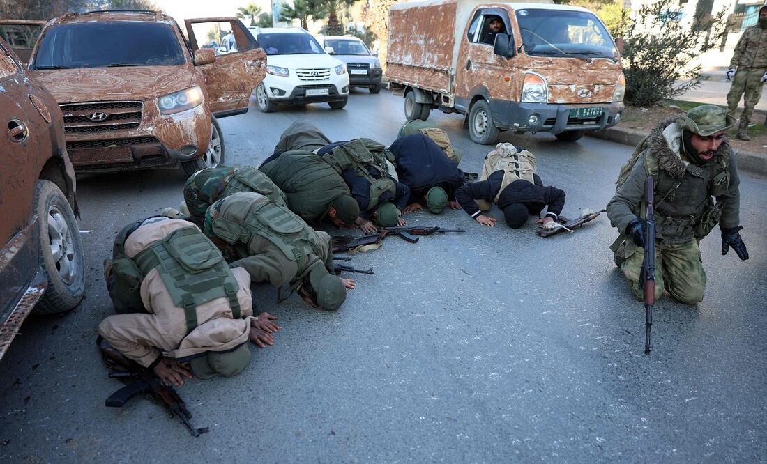Los combatientes antigubernamentales se arrodillan para orar en una calle de Aleppo, después de que los yihadistas y sus aliados entraron en la ciudad del norte de Siria, el 30 de noviembre de 2024. Foto: AFP