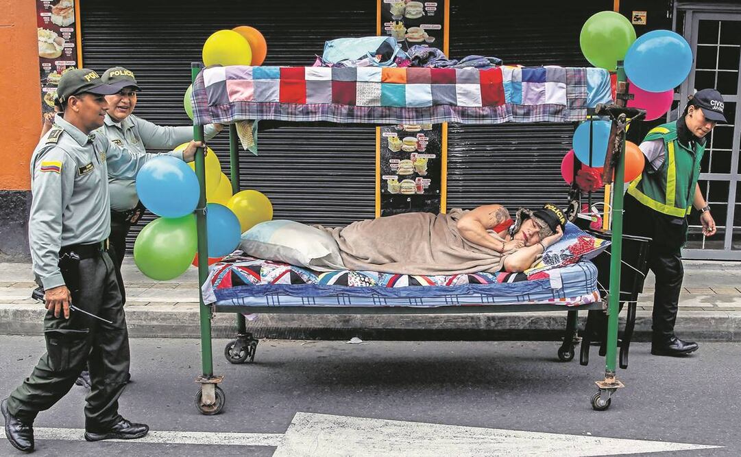 En Colombia la gente celebró el Día Mundial de la Pereza en Itagui. En la imagen, policías retiran a una mujer y su cama ambulante. Foto: Fredy Builes/ AFP.