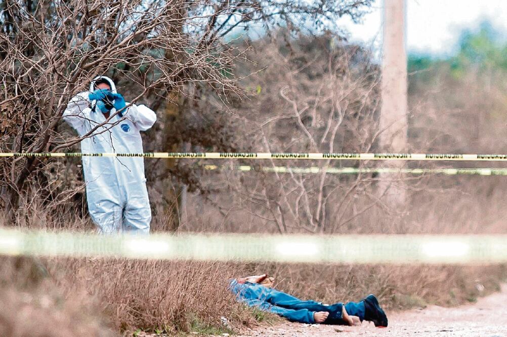 Personal forense trabaja en el sitio donde cuatro hombres fueron asesinados en una carretera en Pesquería, Nuevo León. (JULIO CÉSAR AGUILAR. AFP)