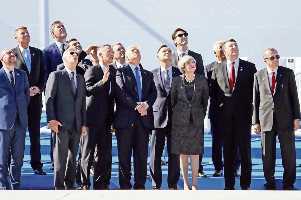Algunos de los jefes de Estado y de gobierno de los países miembros de la OTAN observan el vuelo de un avión momentos antes de la toma de la fotografía oficial, durante la cumbre del organismo celebrada ayer en Bruselas, Bélgica. (DAN KITWOOD. XINHUA)