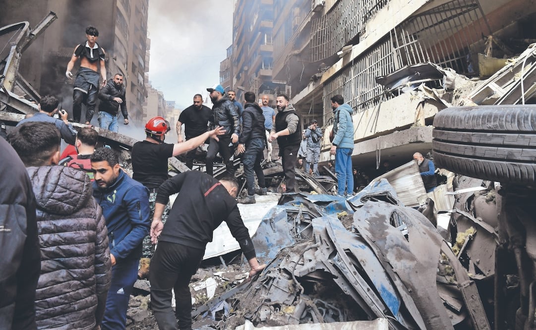 Rescatistas y ciudadanos buscan entre los escombros, tras un ataque aéreo de Israel en el barrio de Corniche al-Mazraa, en Beirut, la capital libanesa. Foto: Wael Hamzeh/ EFE