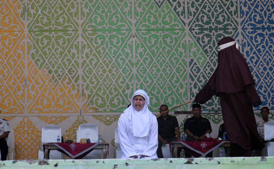 Una mujer de Aceh reacciona a los azotes durante un castigo público por violar la ley islámica en Banda Aceh, Indonesia, el 2 de julio de 2026. El Tribunal de la Sharia y la Fiscalía de Banda Aceh castigaron a los infractores con entre 10 y 30 azotes, incluyendo a una pareja que fue sorprendida besando a sus parejas en directo en la plataforma TikTok. Aceh es la única provincia de Indonesia que aplica la ley islámica y considera las relaciones lésbicas, gays y bisexuales, así como las relaciones sexuales fuera del matrimonio, como infracciones legales. Foto: EFE