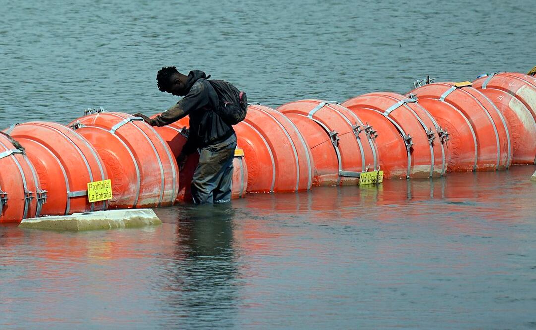 Un migrante colombiano frente la barrera de boyas mientras trata de cruzar el río Bravo de México a Estados Unidos. Foto: AP