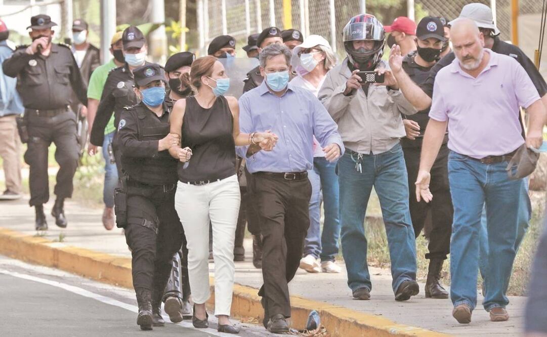 Familiares de Cristiana Chamorro al ser expulsados por agentes del períme-tro de seguridad, durante el allanamiento a la vivienda de la opositora. Foto: Jorge Torres/EFE.