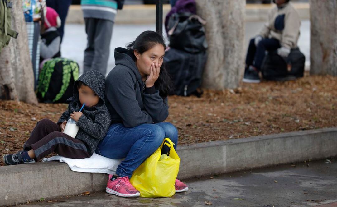 Una mujer migrante descansa con su hijo en El Chaparral, Tijuana (Foto: AP)