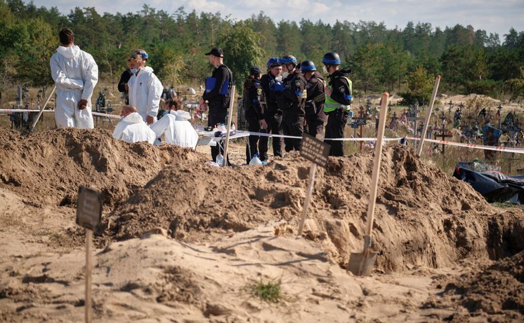 Técnicos forenses trabajan en un lugar de enterramiento cerca de la ciudad recientemente recuperada de Lyman, área de Donetsk, Ucrania. Foto: EFE
