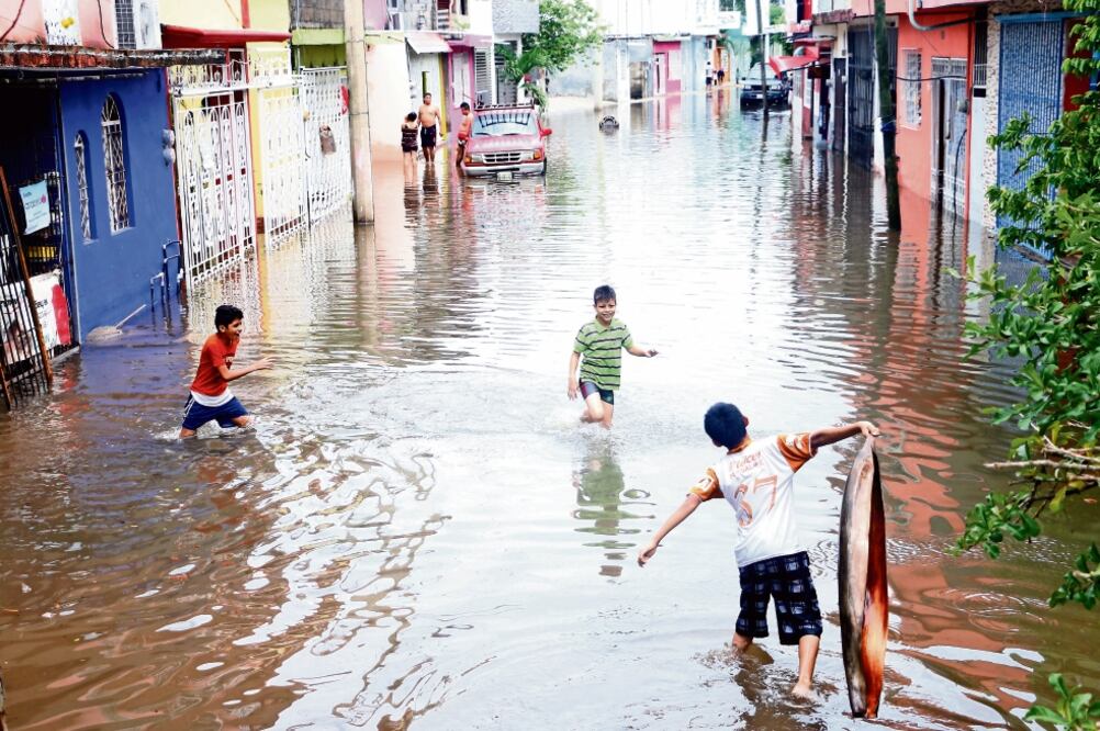 Habitantes tuvieron que cerrar algunas calles para exigir la atención de las autoridades; en tanto algunos pequeños se divertían entre el agua. (CUARTOSCURO)
