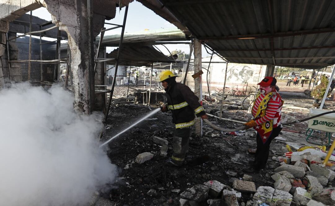 Tultepec firefighter receives help from a local – Photo: Eduardo Verdugo/ AP