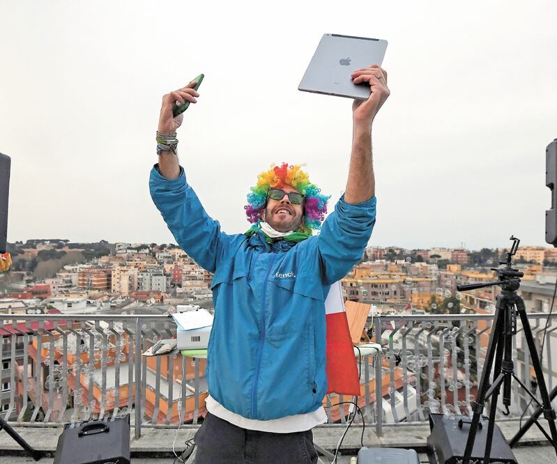 El DJ Francesco Cellini mientras toca para sus vecinos desde la terraza en su departamento, ubicado en Roma, Italia. Foto: ALBERTO LINGRIA. REUTERS
