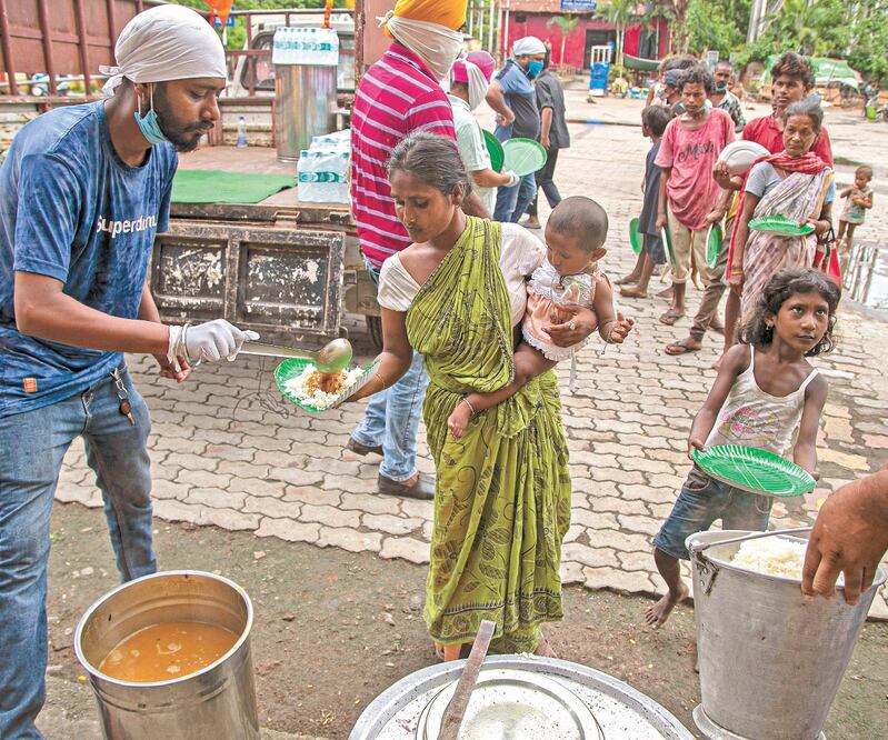 Personas sin hogar recibieron comida distribuida cerca de la estación de tren en Gauhati, India. Foto: ANUPAM NATH. AP