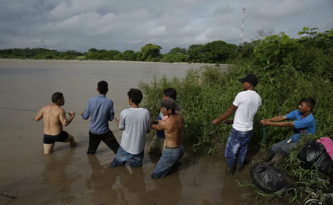 Un grupo de migrantes hondureños varados en el límite de Honduras con El Salvador de la frontera El Amatillo (oriente) se atrevieron hoy a cruzar el Río Goascorán. FOTO: EFE