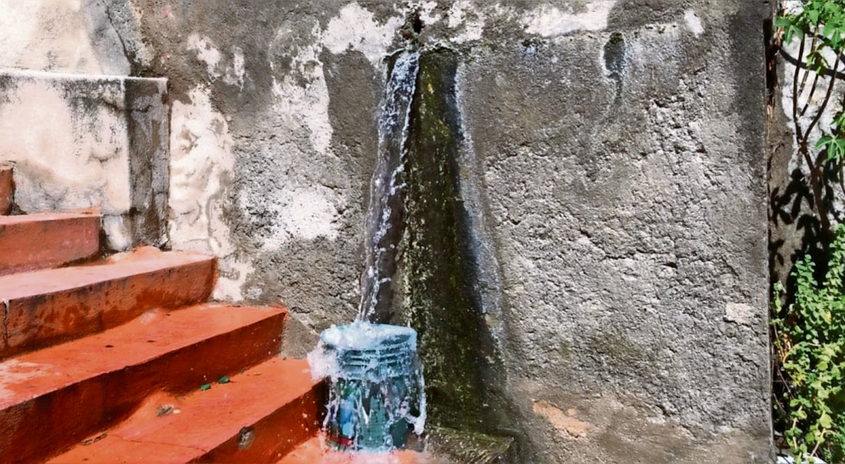 El agua que salía de la tubería rota formó una cascada y un riachuelo.