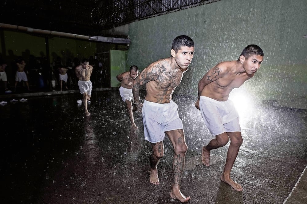 Presuntos pandilleros al ser trasladados por la policía al Centro de Confinamiento Terrorista en Tecoluca, El Salvador. Foto: de AFP