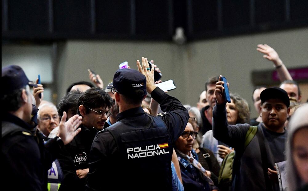 Un policía español gesticula mientras los pasajeros esperan para subir a su tren en la estación de Santa Justa de Sevilla, el 29 de abril de 2025, un día después de un apagón masivo que afectó a toda la península Ibérica y al sur de Francia. Foto: AFP