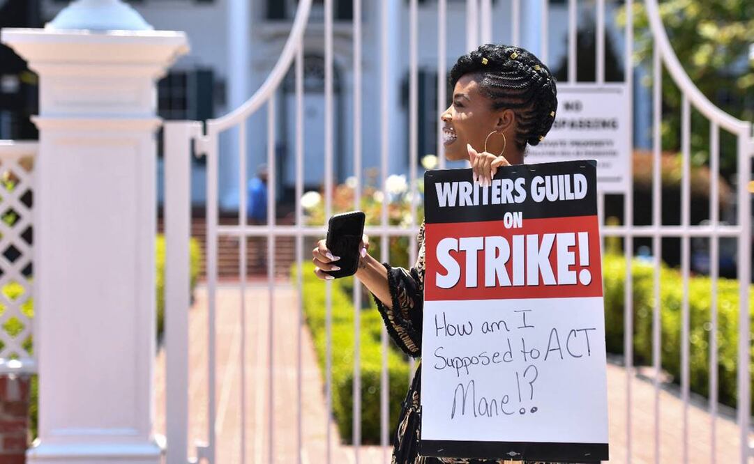 La actriz estadounidense Brandee Evans sostiene un cartel de huelga mientras asiste a un mitin. Foto: AFP.
