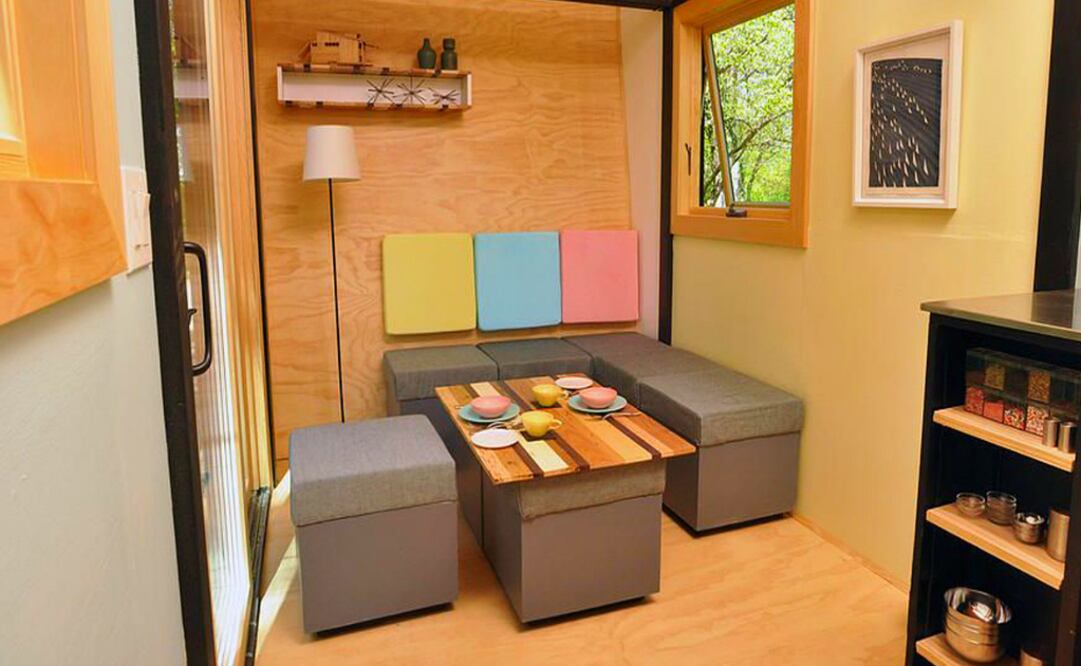 La casa tiene una extensión de 13 metros cuadrados y está divida en dos zonas, compuestas por una cocina, un comedor, un dormitorio y un baño. Las mesas funcionan también como escritorios.  (Foto: Cortesía The Toybox Home)