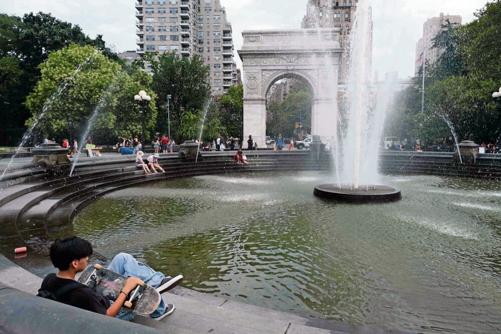 La gente intenta mantenerse fresca junto a la fuente en Washington Square Park durante una ola de calor, en la ciudad de Nueva York. Foto: AFP