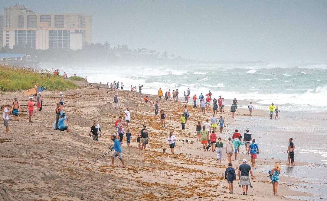 Los bañistas caminan en la playa de Juno, Florida; la tormenta tropical Isaías pasa cerca de las costas de ese estado. Foto: CRISTOBAL HERRERA-ULASHKEVICH. EFE