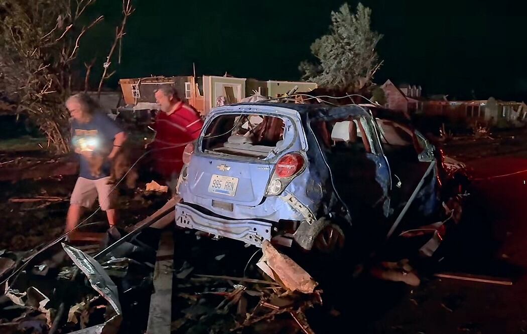 En esta imagen fija obtenida del Tribunal Fiscal del Condado de Laurel, Kentucky, se observa a residentes locales inspeccionando los daños causados por un tornado en el condado de Laurel, cerca de London, Kentucky. Foto: AFP