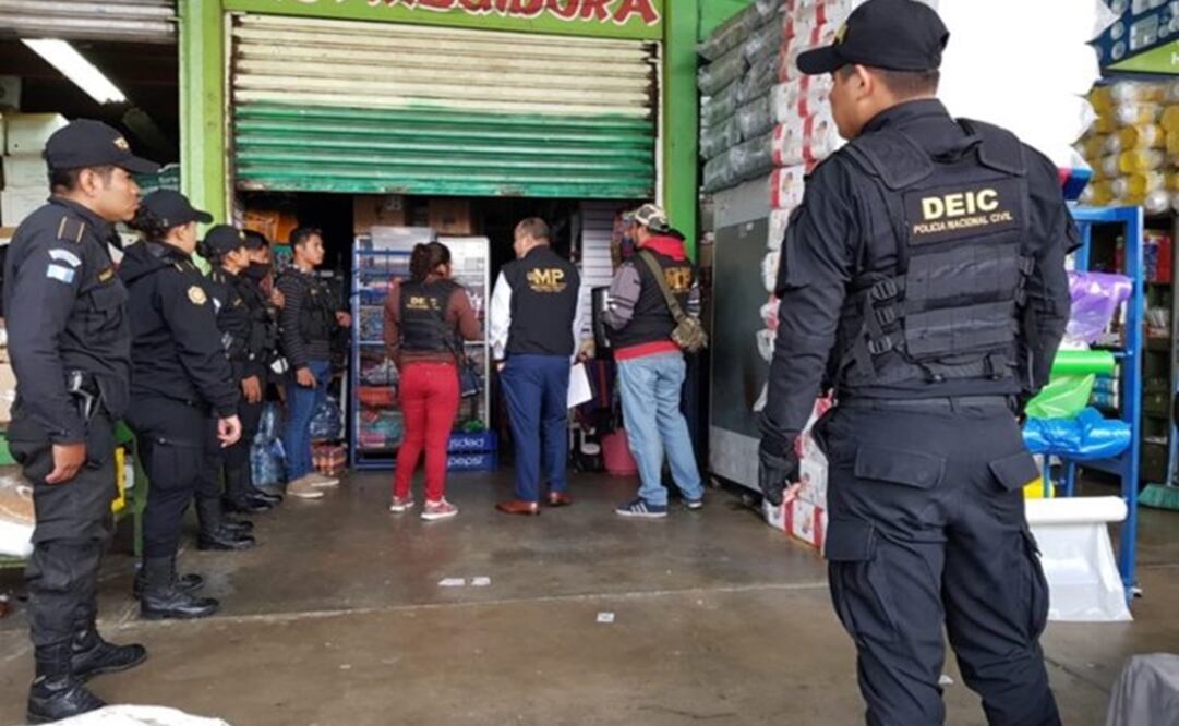 Policías custodian un sitio allanado en el sur de la capital de Guatemala, para atacar una red de tráfico de personas y “lavado” de dinero. Foto: Cortesía 