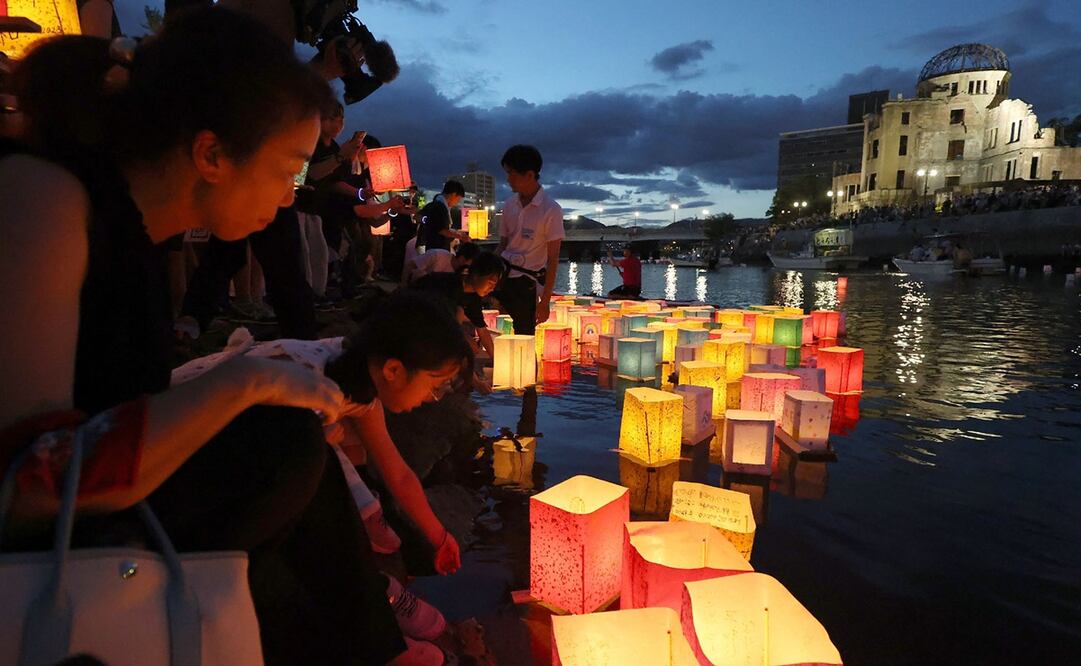 Las personas lanzan linternas de papel en el río Motoyasu junto al Salón de Promoción Industrial de la Prefectura de Hiroshima, comúnmente conocido como el domo de la bomba atómica. Foto: AFP