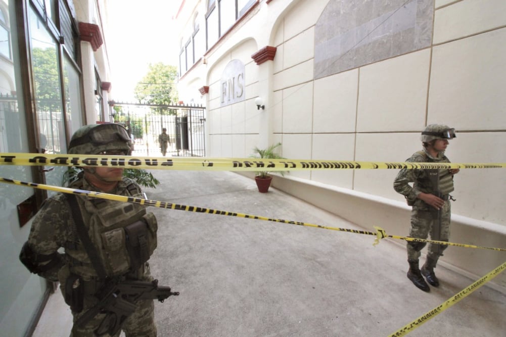 Elementos de la Marina resguardan las instalaciones de la empresa First National Security, donde usuarios inconformes mantuvieron un plantón para impedir que sus pertenencias fueran trasladadas a otro lugar. (EFE)