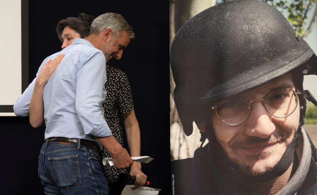 Colegas y amigos se abrazan durante una ceremonia conmemorativa en Kiev, Ucrania, junto a un retrato del periodista de AFP Arman Soldin, asesinado en la región de Donbas. Foto: AP