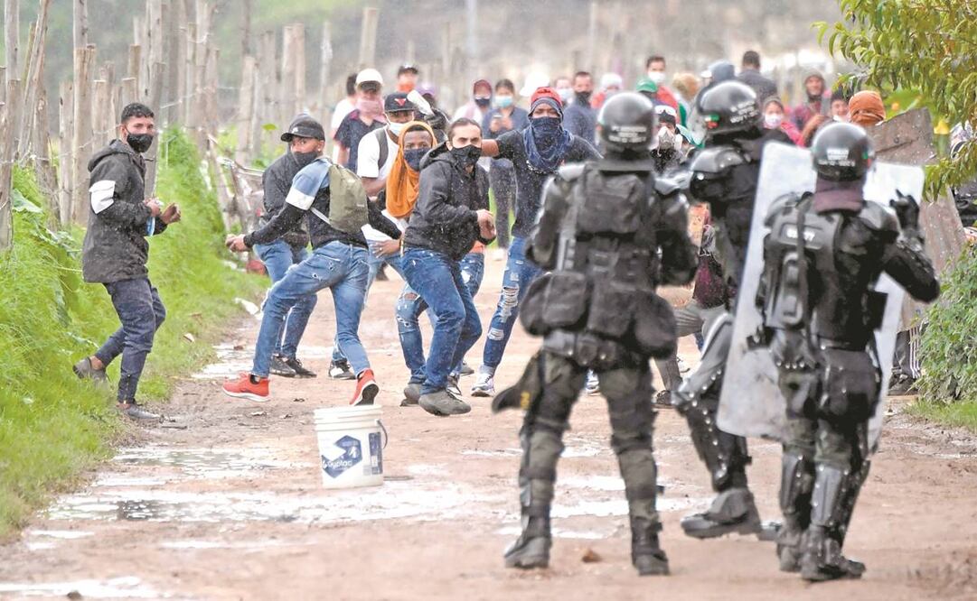 Manifestantes se enfrentan a la policía antimotines durante una protesta en la localidad colombiana de Facatativá. Foto: Raúl Arboleda/ AFP.