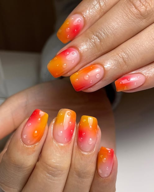 Uñas wet nails con degradado naranja y rosa para el verano. Foto: Instagram @rebeccapaintsnails