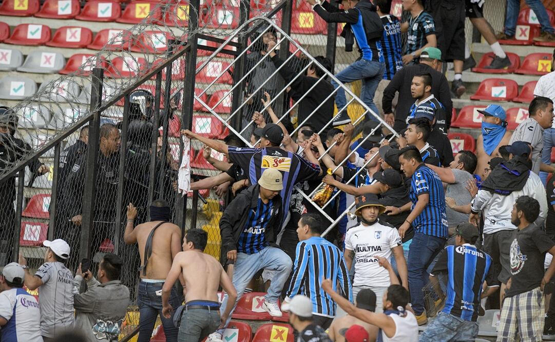 Aficionados del Querétaro invadieron gradas y campo del estadio Corregidora para agredir a seguidores del Atlas - FOTO: AP