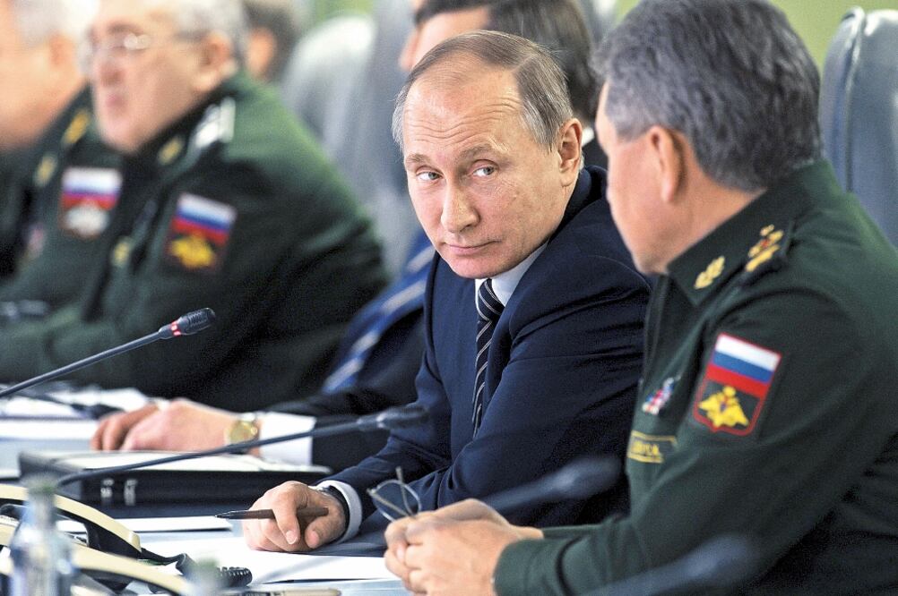 El presidente ruso, Vladimir Putin, con su ministro de Defensa, Sergei Shoigu, durante una reunión con líderes de la industria militar, en Moscú. FOTO: MIKHAIL KLIMENTYEV. REUTERS