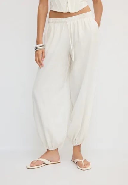 Pantalón bombacho blanco con cintura elástica ajustable, lazo ajustable y largo al tobillo con acabado en puño elástico. Foto: Stradivarius