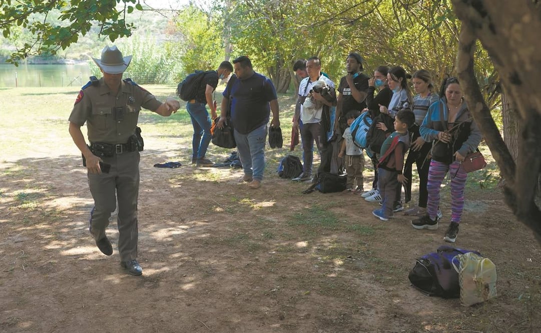 Un agente, con un grupo de migrantes que cruzaron la frontera y se entregaron en Del Río, Texas. Foto: Eric Gay/ AP.