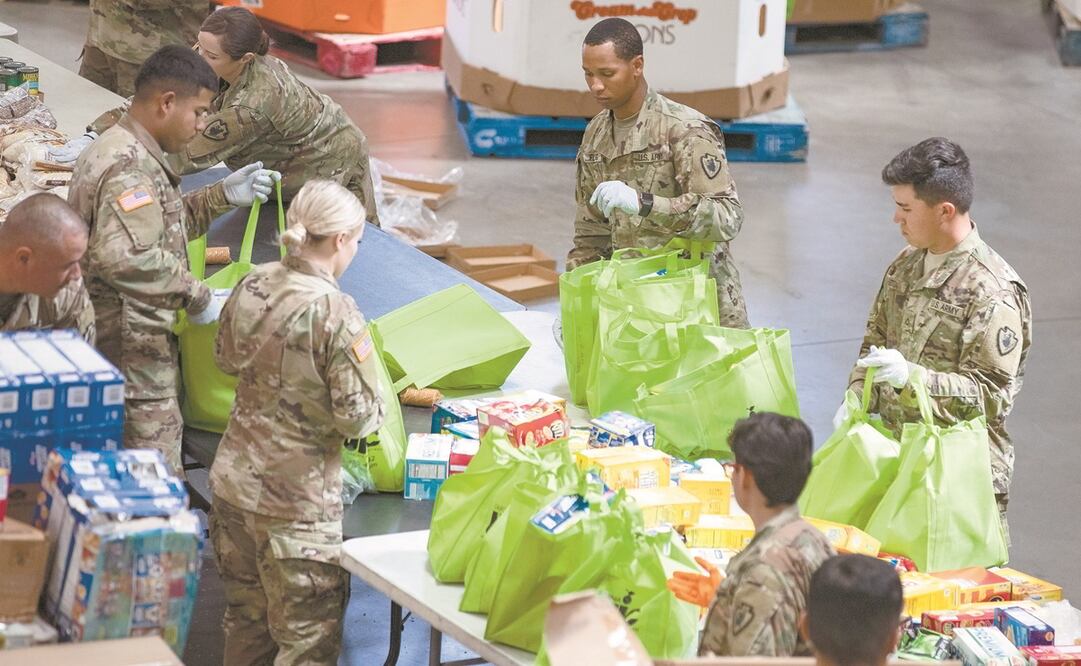 Soldados de la Guardia Nacional colocan comida donada en bolsas para dar a personas necesitadas, en medio de la crisis del Covid-19, en Indio, California. Foto: ETIENNE LAURENT. EFE